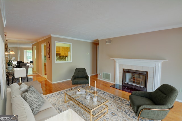 1005 Berkeley Woods Dr, Duluth, GA 30096 - living area with crown molding, wood finished floors, a tile fireplace, and baseboards