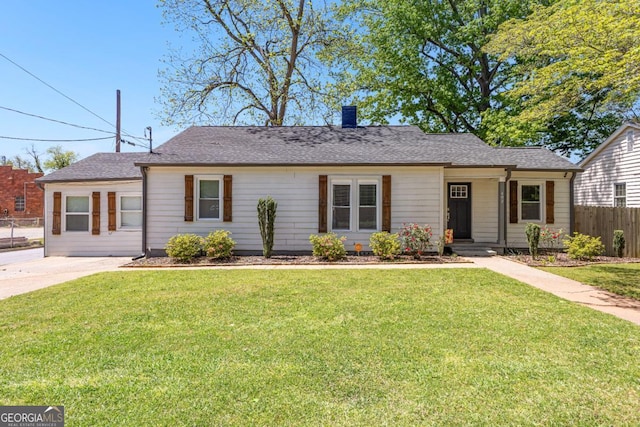 ranch-style house with roof with shingles, a chimney, a front yard, and fence
