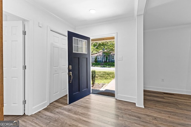 entrance foyer with wood finished floors, baseboards, and ornamental molding