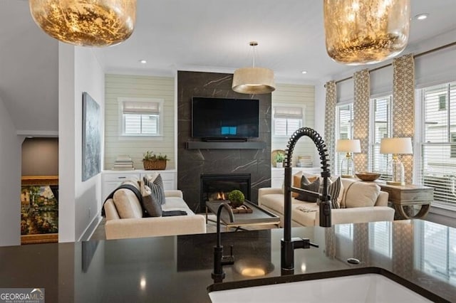 interior space with a premium fireplace, open floor plan, a sink, and dark countertops