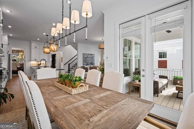 dining area with recessed lighting, stairway, wood finished floors, french doors, and a notable chandelier