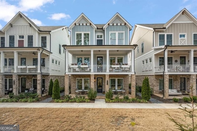 view of front of property featuring a balcony, board and batten siding, ceiling fan, and a front yard