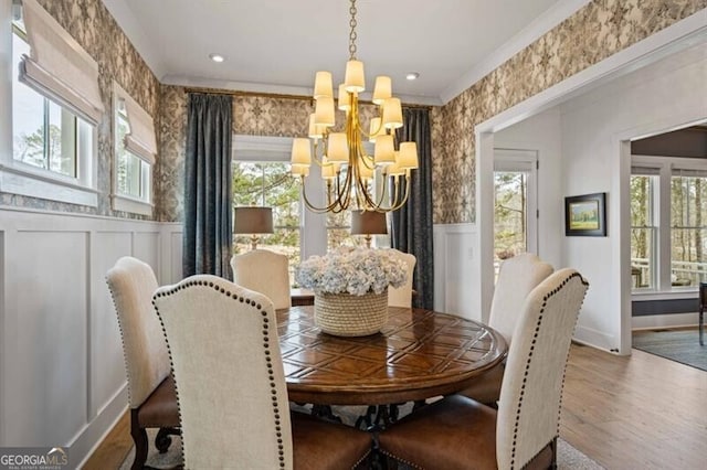 dining room with wood finished floors, a healthy amount of sunlight, and a notable chandelier