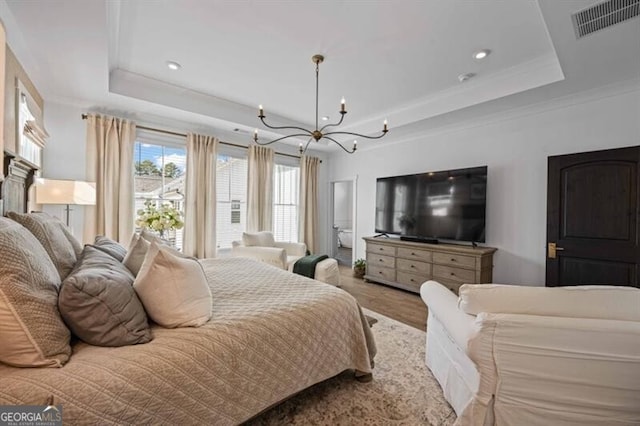 bedroom with wood finished floors, an inviting chandelier, a raised ceiling, visible vents, and recessed lighting