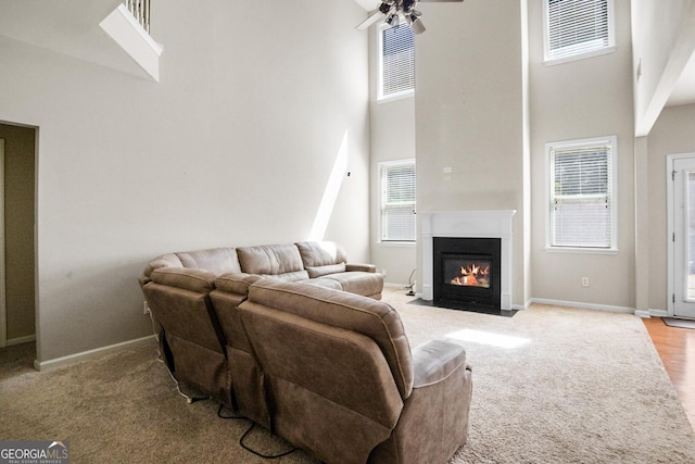 1502 Silver Mist Cir, Powder Springs, GA 30127 - living room featuring baseboards, a high ceiling, a ceiling fan, and light carpet