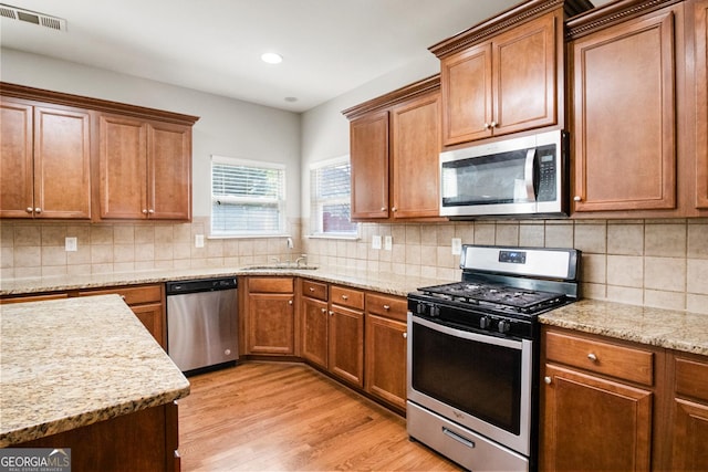 1502 Silver Mist Cir, Powder Springs, GA 30127 - kitchen with light wood-style flooring, a sink, tasteful backsplash, visible vents, and appliances with stainless steel finishes