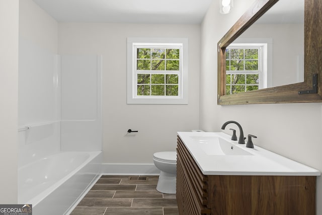 1271 Hayes St, Madison, GA 30650 - bathroom featuring wood finish floors, a healthy amount of sunlight, toilet, and baseboards