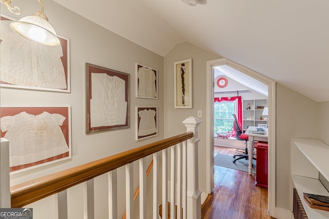 hallway featuring dark wood-type flooring, lofted ceiling, and an upstairs landing
