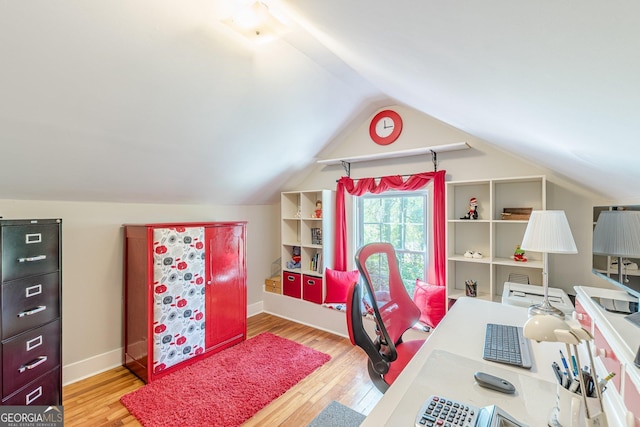 home office featuring lofted ceiling, baseboards, and wood finished floors