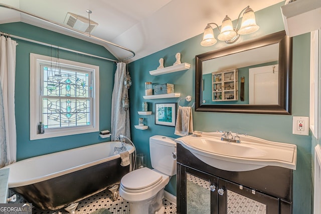 bathroom with a soaking tub, toilet, vaulted ceiling, visible vents, and vanity