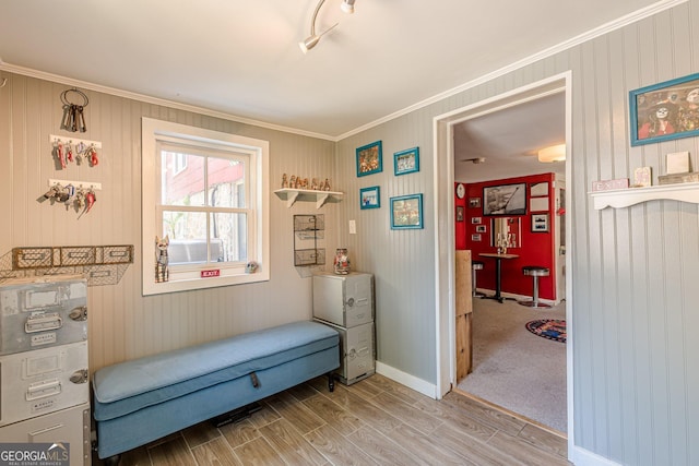 living area with baseboards, light wood-style floors, and crown molding
