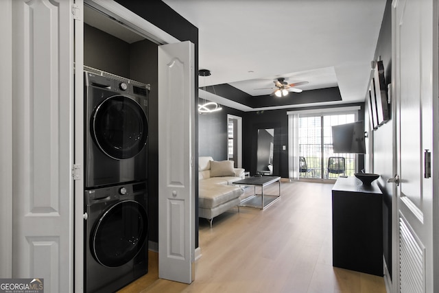 195 14th St Unit 1403, Atlanta, GA 30309 - laundry room featuring stacked washer and clothes dryer, a ceiling fan, and light wood-style floors