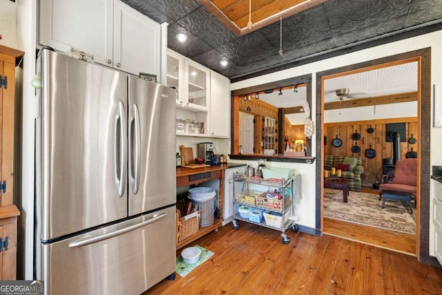 937 Fern Dr, Morganton, GA 30560 - kitchen featuring white cabinets, an ornate ceiling, light wood-style flooring, and freestanding refrigerator