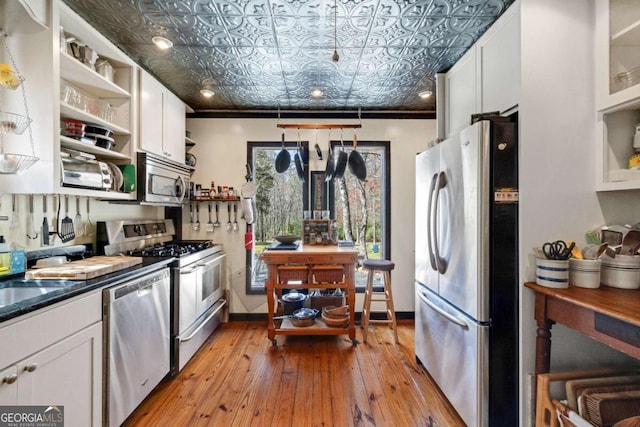 937 Fern Dr, Morganton, GA 30560 - kitchen with an ornate ceiling, open shelves, light wood-style floors, white cabinets, and appliances with stainless steel finishes
