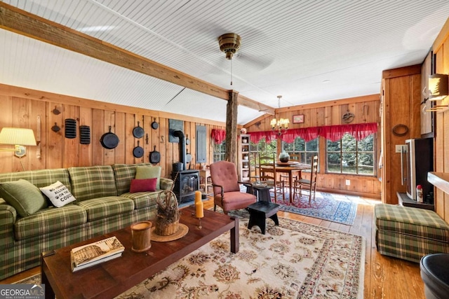 937 Fern Dr, Morganton, GA 30560 - living room featuring hardwood / wood-style flooring, lofted ceiling with beams, an inviting chandelier, a wood stove, and wood walls