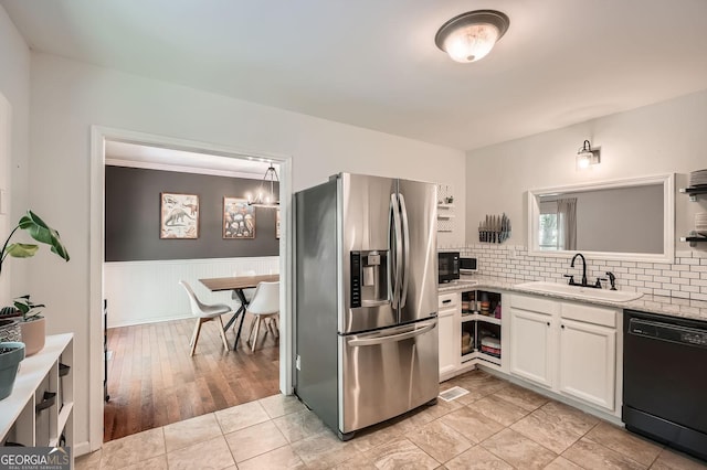 kitchen with white cabinets, a sink, dishwasher, a wainscoted wall, and stainless steel refrigerator with ice dispenser