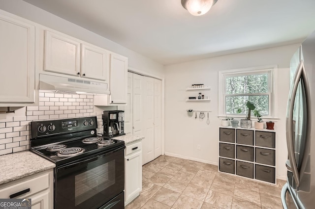 kitchen featuring backsplash, black range with electric stovetop, white cabinets, freestanding refrigerator, and under cabinet range hood