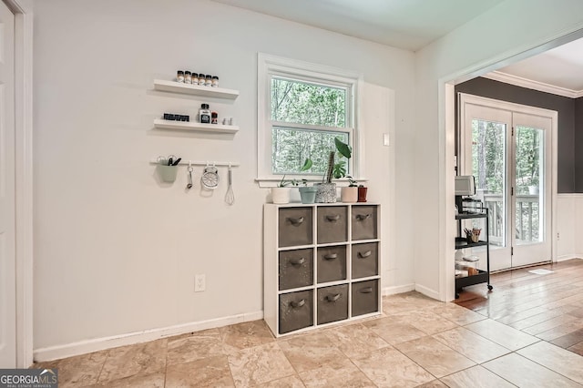 doorway with crown molding and baseboards