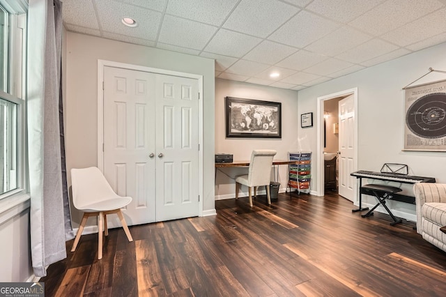 office space with recessed lighting, dark wood-style flooring, baseboards, and a paneled ceiling