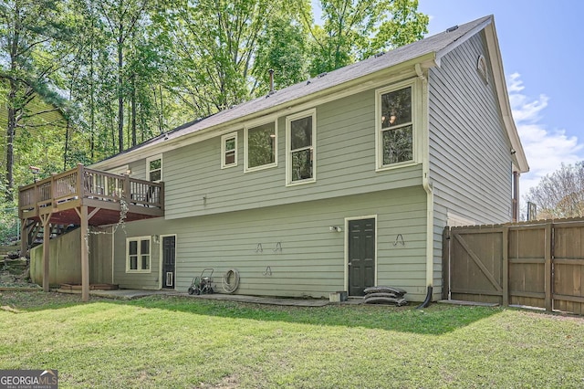 back of house featuring a lawn, fence, and a deck