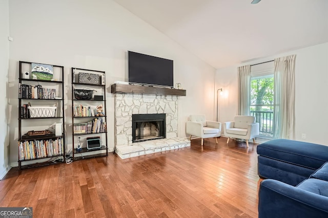 living room with high vaulted ceiling, wood finished floors, and a fireplace