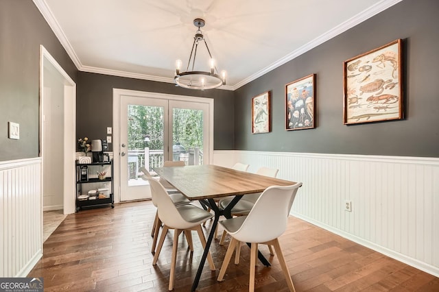 dining area with an inviting chandelier, ornamental molding, wainscoting, and hardwood / wood-style flooring