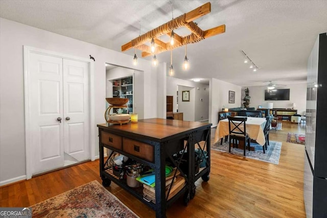 dining room with track lighting, wood finished floors, and a ceiling fan