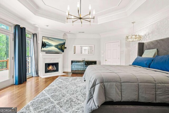 315 Mossy Pointe, Duluth, GA 30097 - bedroom with an inviting chandelier, wood finished floors, and a tray ceiling