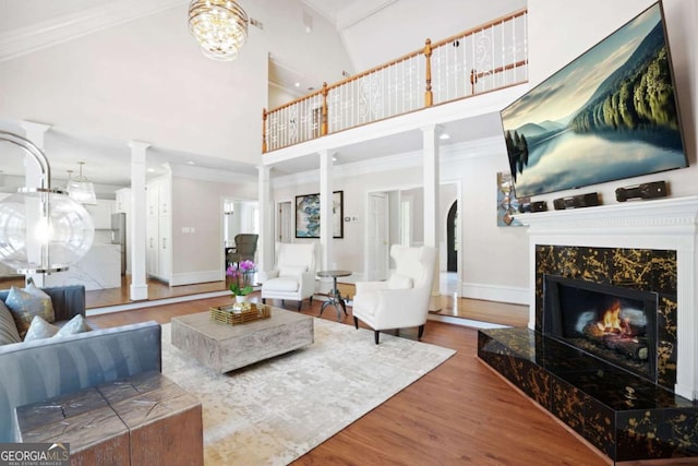 315 Mossy Pointe, Duluth, GA 30097 - living area featuring a high ceiling, ornate columns, wood finished floors, a premium fireplace, and baseboards