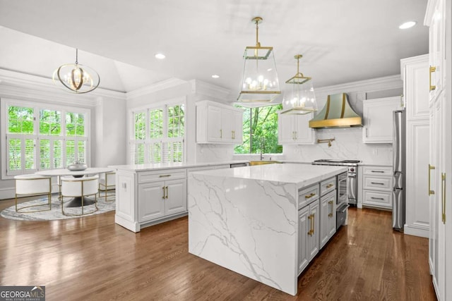 315 Mossy Pointe, Duluth, GA 30097 - kitchen featuring stainless steel appliances, an inviting chandelier, a center island, custom exhaust hood, and white cabinetry