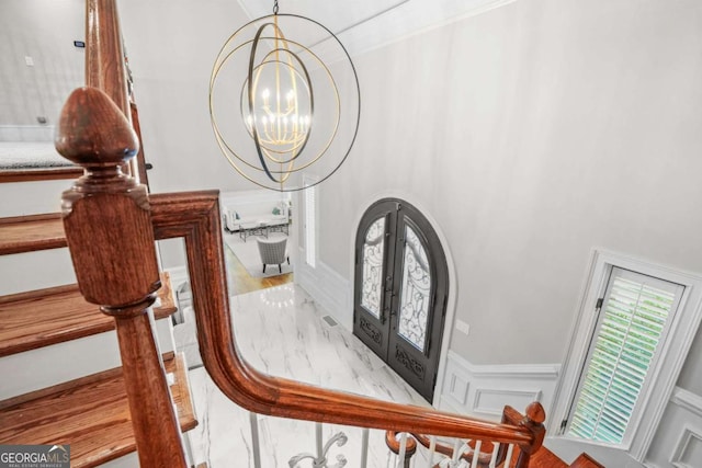 315 Mossy Pointe, Duluth, GA 30097 - foyer entrance featuring a decorative wall, a wainscoted wall, a notable chandelier, and french doors