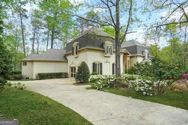 315 Mossy Pointe, Duluth, GA 30097 - french country home featuring a garage, driveway, a shingled roof, and stucco siding