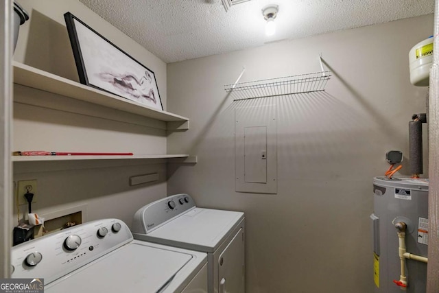 clothes washing area featuring electric water heater, washing machine and dryer, and a textured ceiling