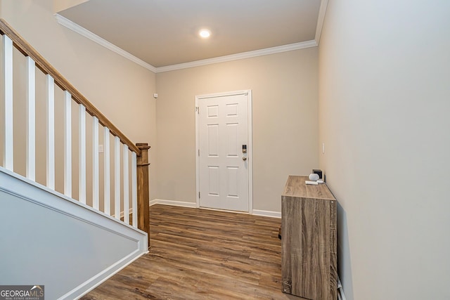 foyer entrance featuring stairs, ornamental molding, wood finished floors, and baseboards