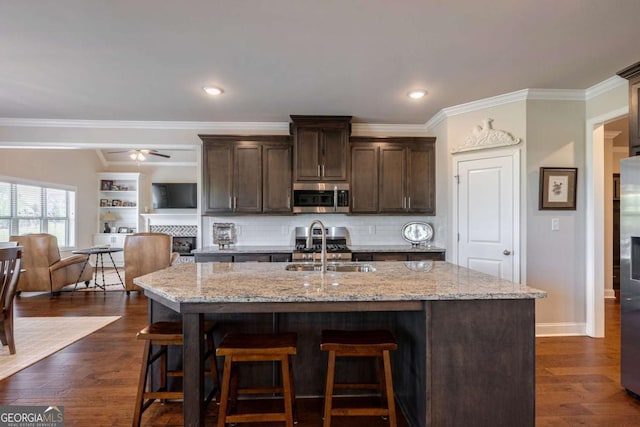 2424 Princeton Bend Way, Bogart, GA 30622 - kitchen with stainless steel appliances, dark brown cabinets, a breakfast bar, light stone countertops, and crown molding