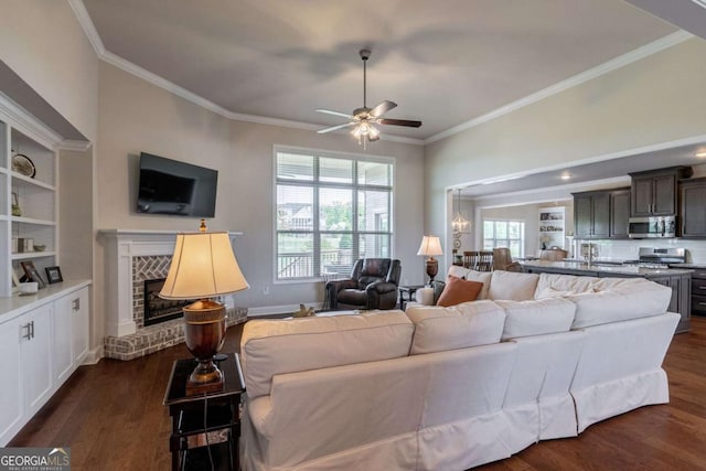 2424 Princeton Bend Way, Bogart, GA 30622 - living room with a fireplace, crown molding, dark wood-style flooring, a ceiling fan, and built in shelves