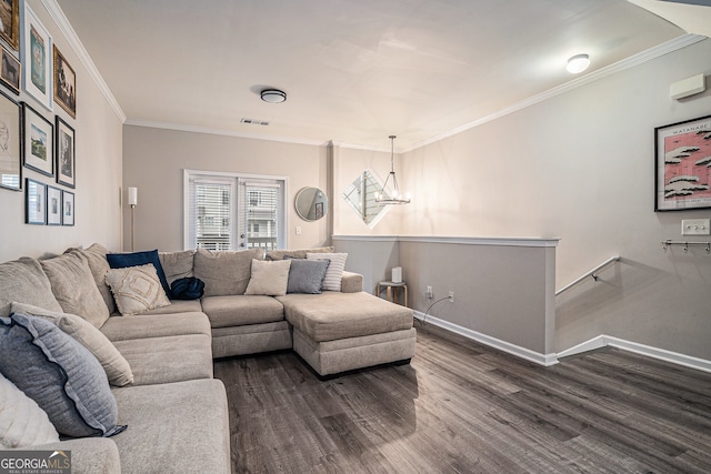living room with a chandelier, visible vents, baseboards, ornamental molding, and dark wood-style floors