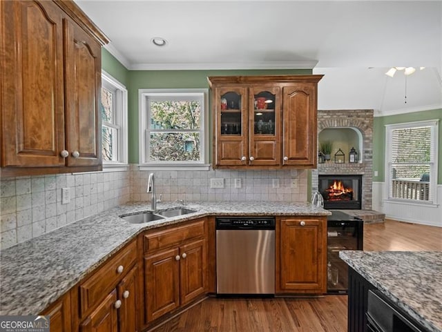 kitchen featuring dishwasher, crown molding, a sink, and dark wood-style floors