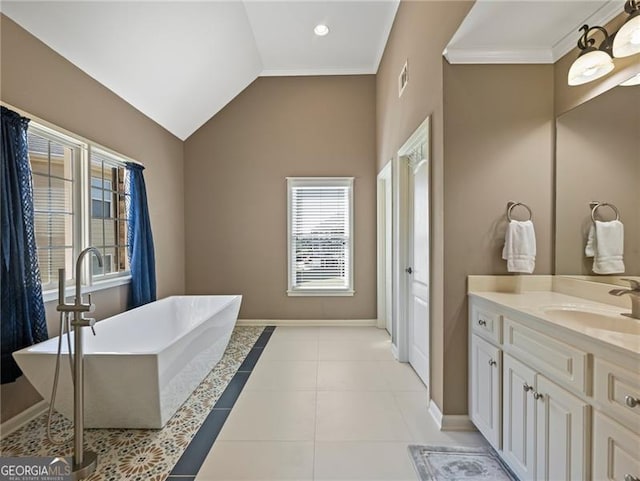 full bath with tile patterned floors, vanity, a freestanding bath, baseboards, and ornamental molding