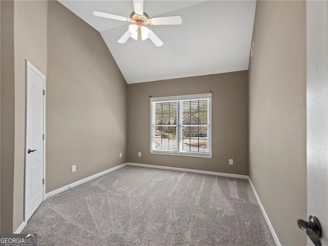 carpeted empty room featuring vaulted ceiling, baseboards, and ceiling fan