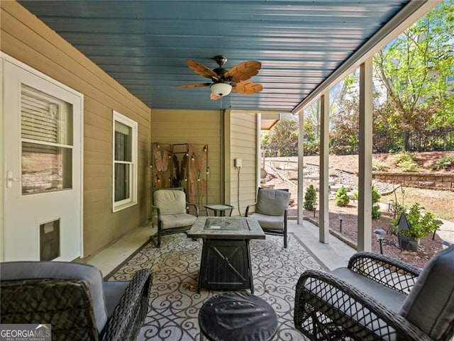 sunroom with a ceiling fan and an outdoor fire pit