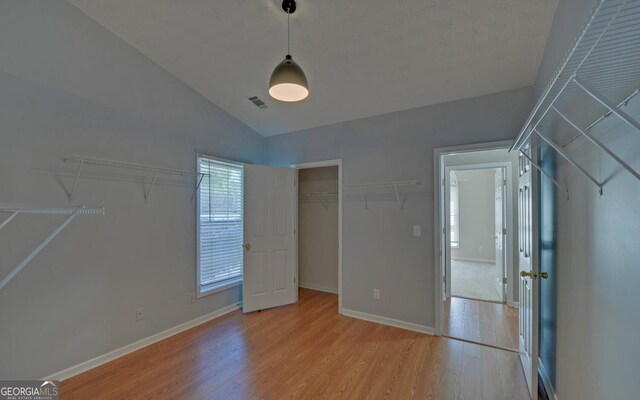 2800 Araglin Dr, Dacula, GA 30019 - unfurnished bedroom featuring light wood finished floors, baseboards, visible vents, and lofted ceiling