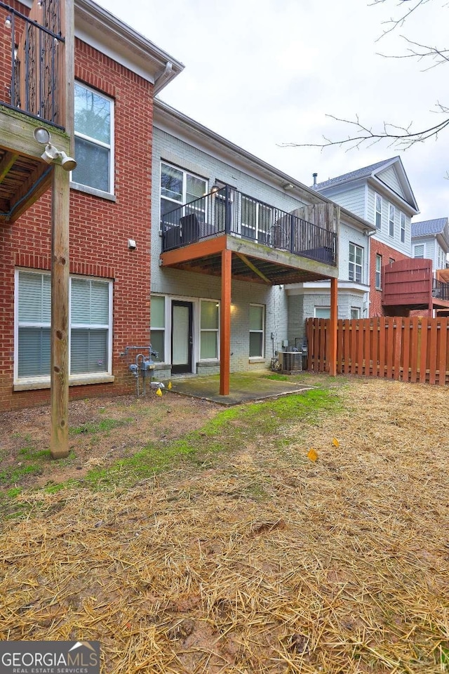 back of property with brick siding and fence
