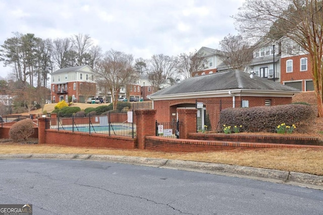 exterior space featuring a pool, fence, and a residential view
