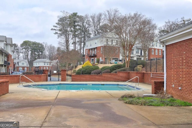 community pool featuring fence and a residential view