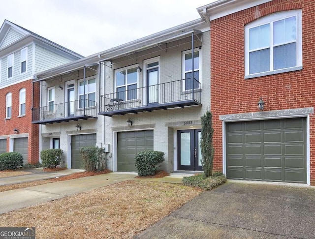 multi unit property featuring brick siding, driveway, and a garage