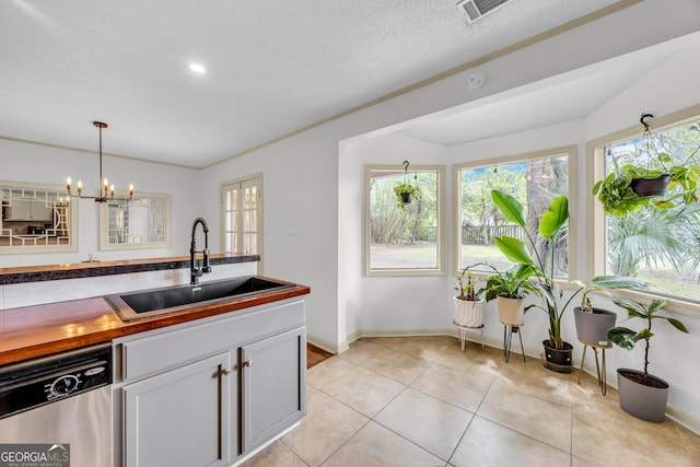 kitchen featuring hanging light fixtures, a sink, light tile patterned floors, dishwasher, and visible vents