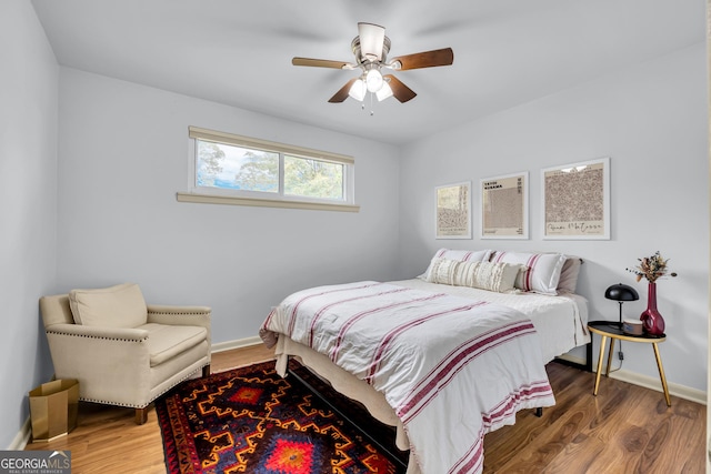 bedroom with wood finished floors, baseboards, and ceiling fan
