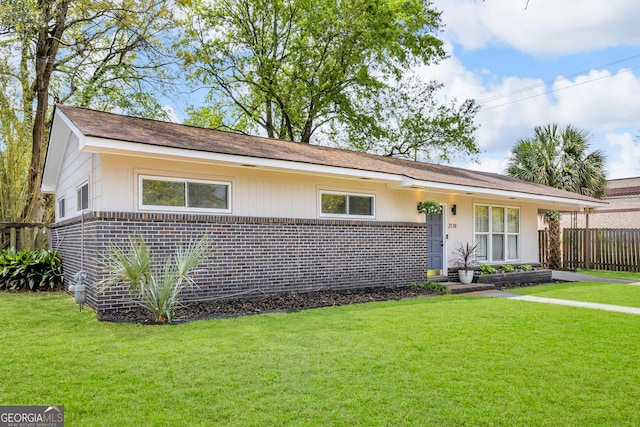 single story home featuring a front lawn, brick siding, and fence