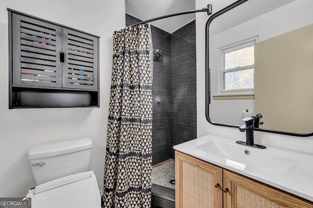 full bathroom with toilet, vanity, and a stall shower